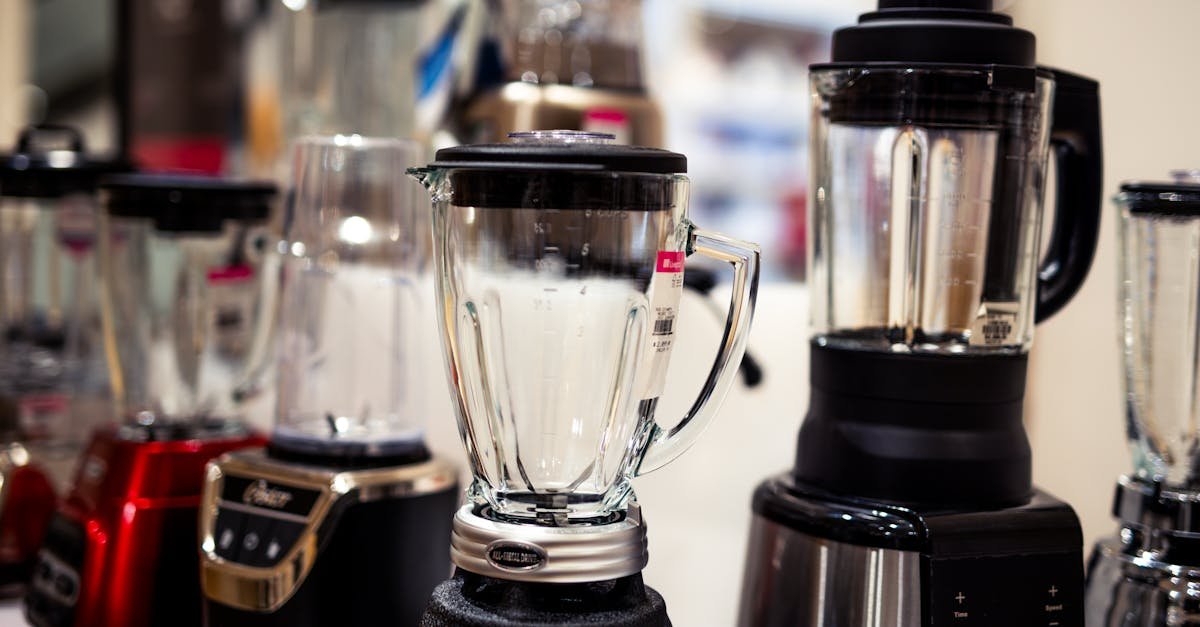 A variety of kitchen blenders displayed on a showroom countertop.